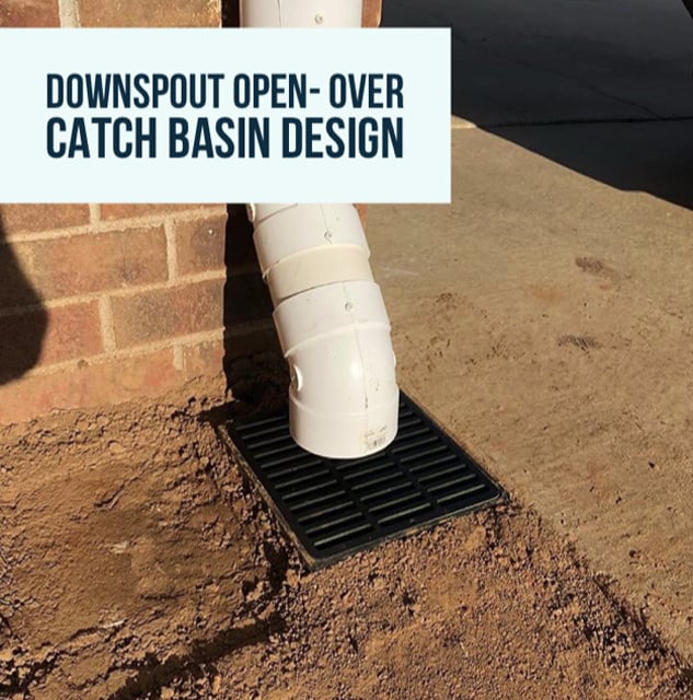 Downspout drainage system connecting to a catch basin on a brick wall