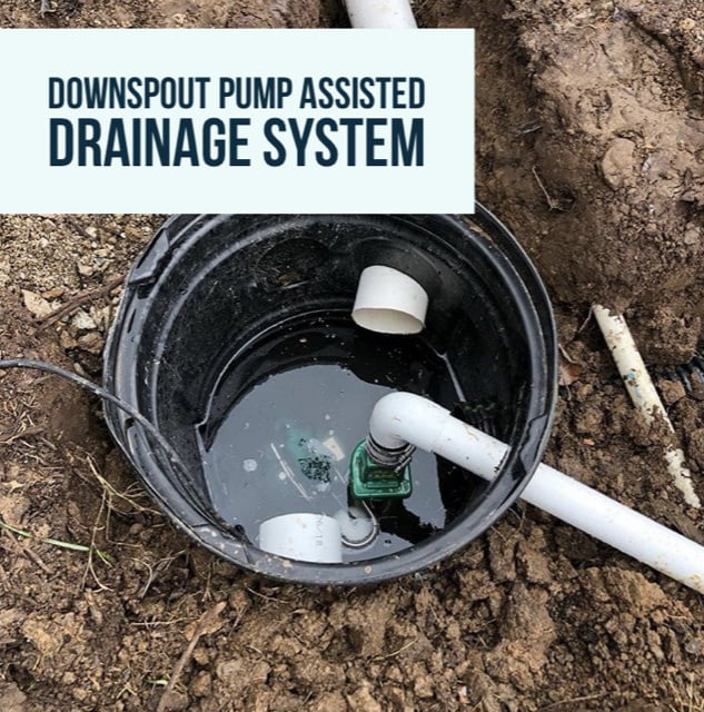 Downspout pump-assisted drainage system with a water-filled basin and connecting PVC pipes